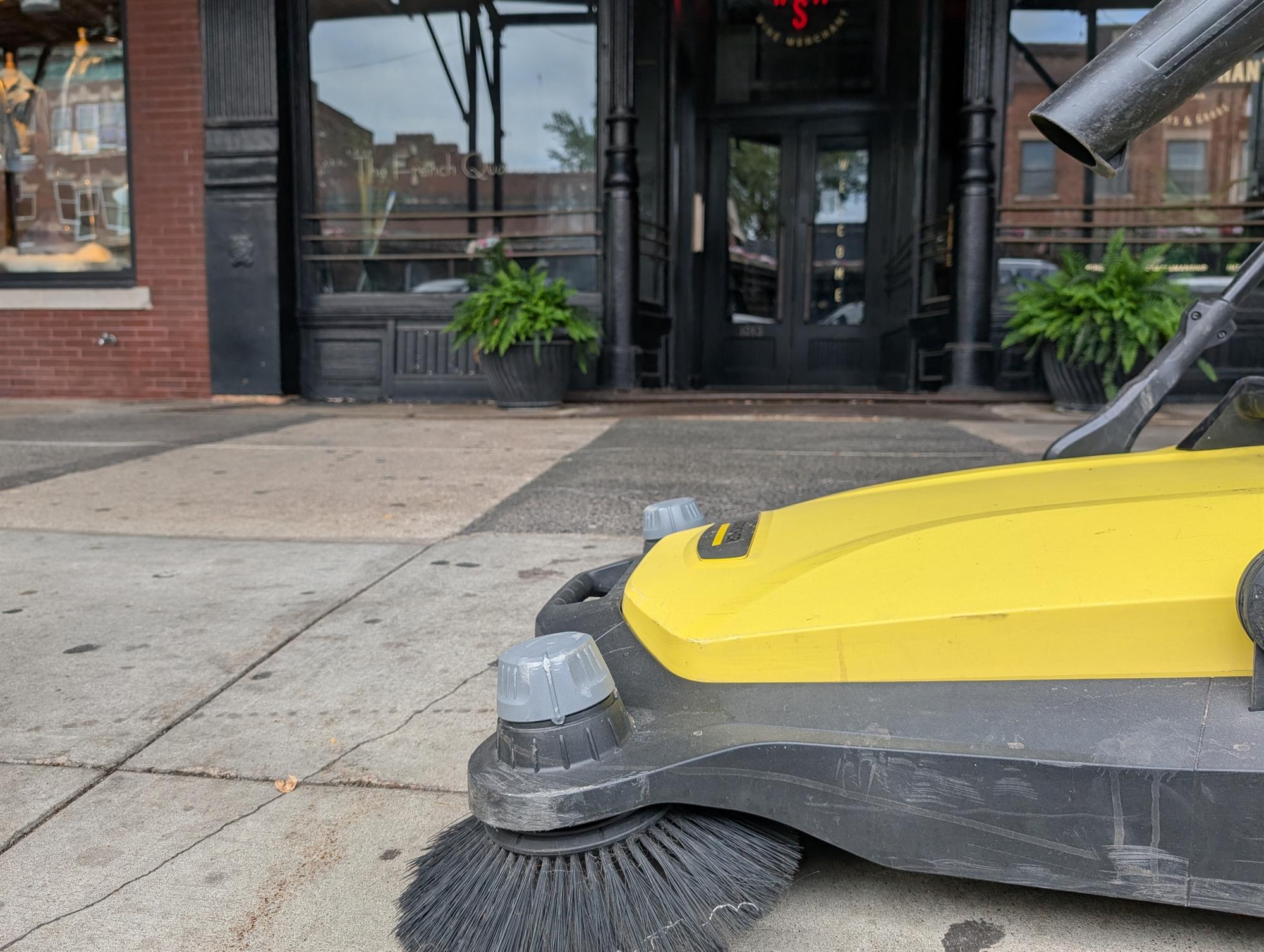 A push sweeper at work on an Old Market sidewalk.